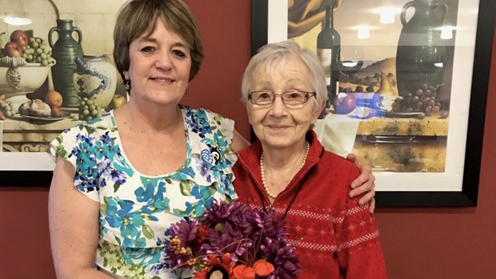 Two elderly women with lovely bouquet at Sweetgrass residence